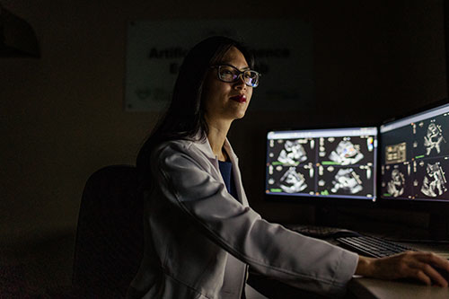 Dr. Christina Luong in front of computer screens AI Echo Core Lab