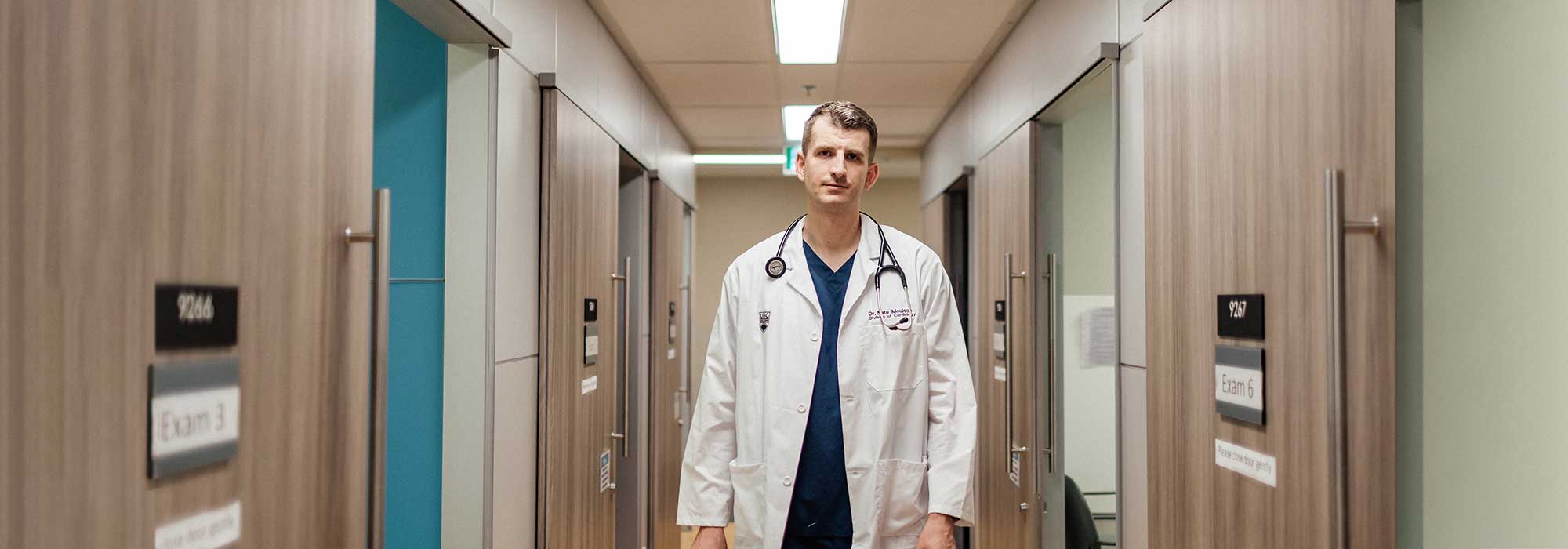 Dr. Nate Moulson walking down exam rooms corridor